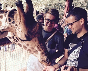Freiwillige Christopher Rohles und Inken Koenemund füttern eine Giraffe