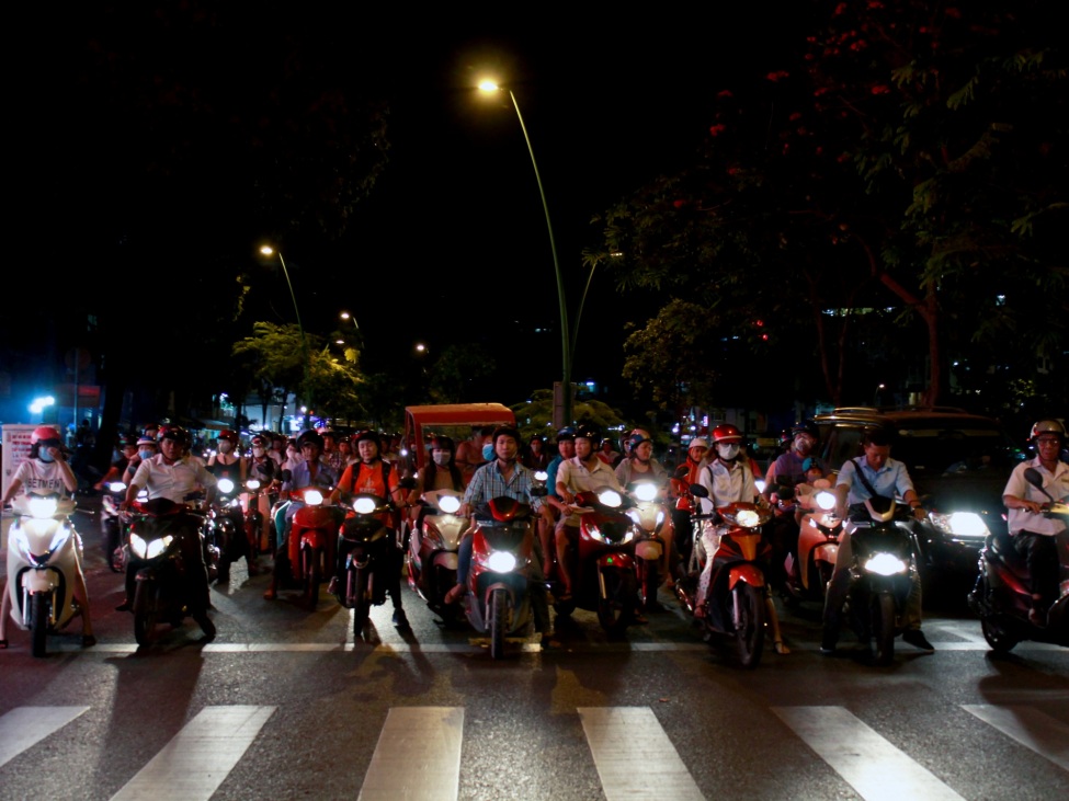 Mopedfahrer*innen in Saigon bei Nacht